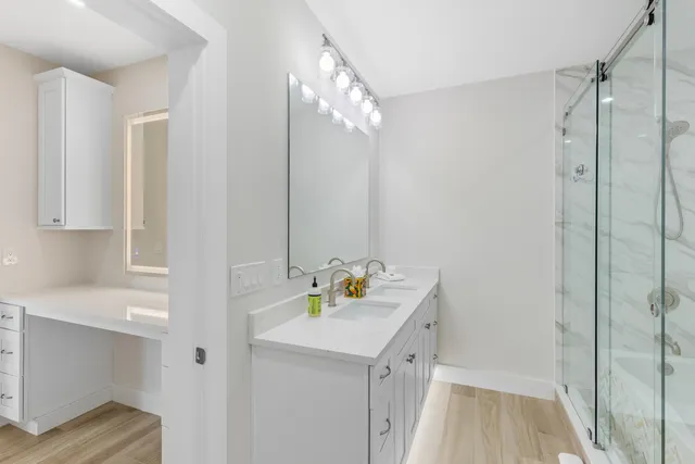 a bathroom with a shower sink and mirror