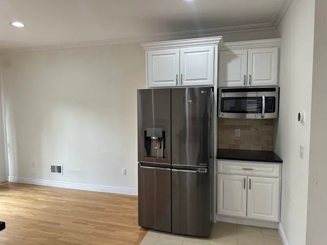 a metallic refrigerator freezer sitting in a kitchen