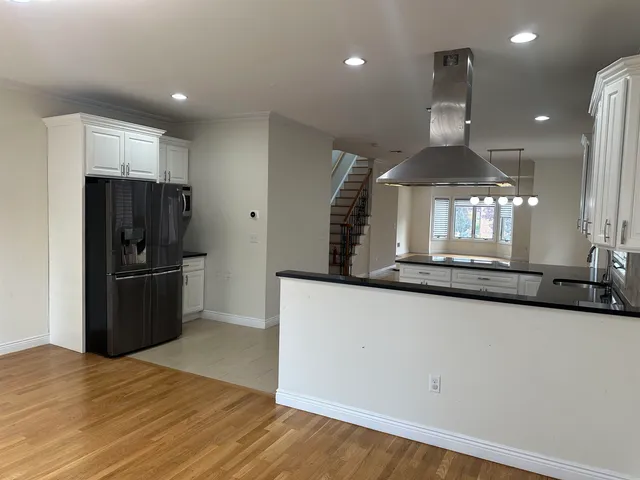 a kitchen with stainless steel appliances granite countertop a refrigerator a stove and a sink