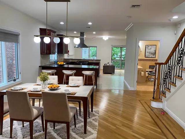 a kitchen with a dining table chairs stainless steel appliances and cabinets