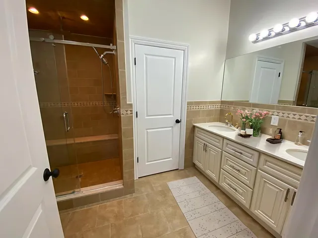 a bathroom with a shower sink and mirror