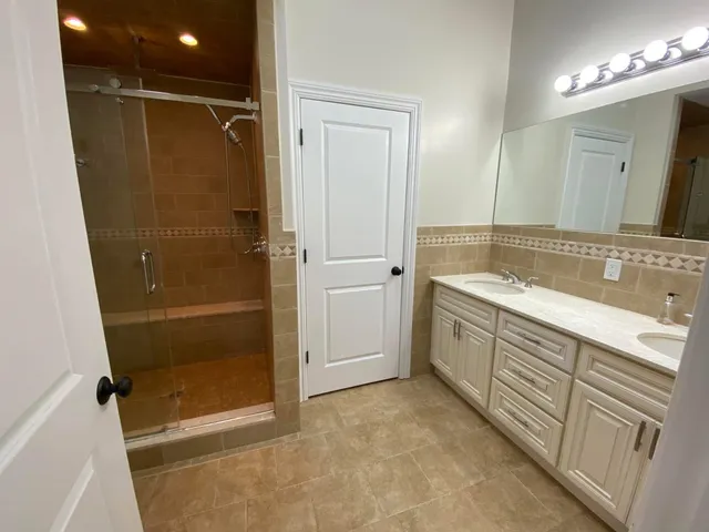 a bathroom with a shower sink and mirror