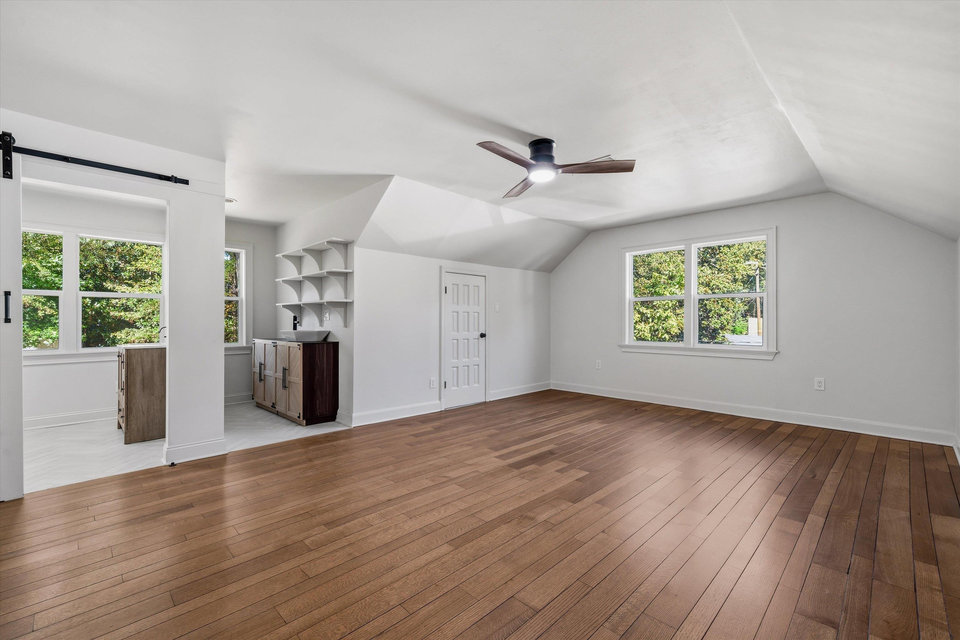 159 Perkins Extension Memphis, TN 38117 - Photo 28 of 37 an empty room with wooden floor a ceiling fan and windows