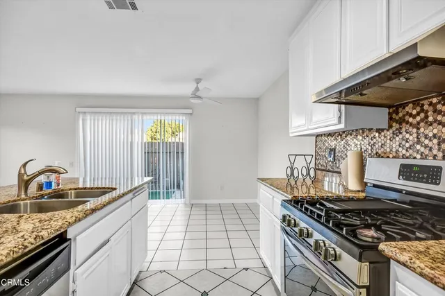 a kitchen with granite countertop a stove and a sink