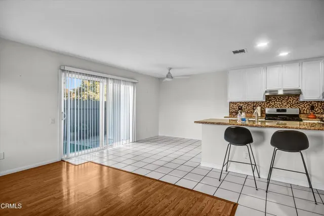 a kitchen with granite countertop a stove a sink and a cabinets
