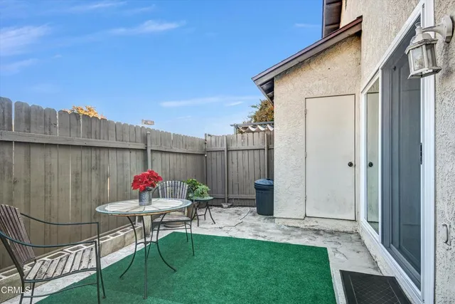 a view of a chair and table in backyard of the house