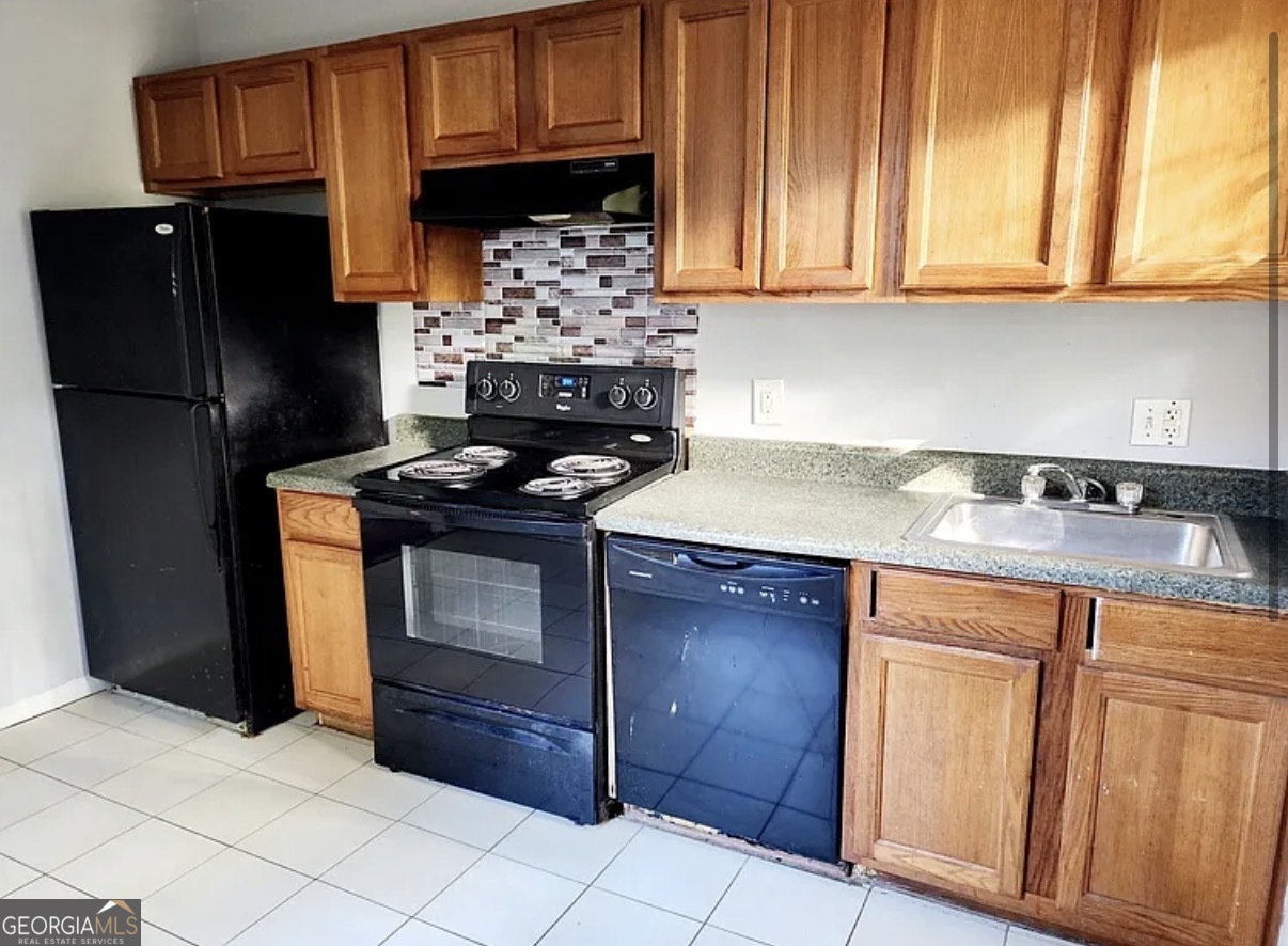 1802 Lee Street Decatur, GA 30035 - Photo 3 of 6 a kitchen with granite countertop wooden cabinets and a stove top oven