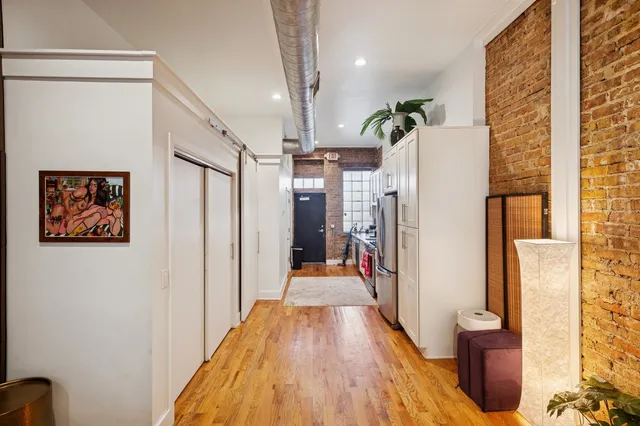 a view of a hallway with wooden floor and staircase