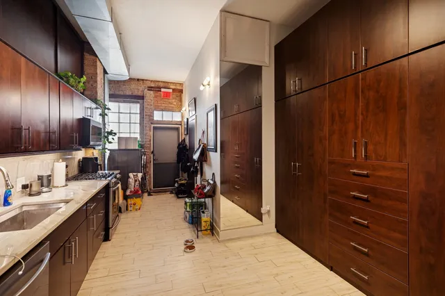a kitchen with stainless steel appliances kitchen island granite countertop a refrigerator and a sink