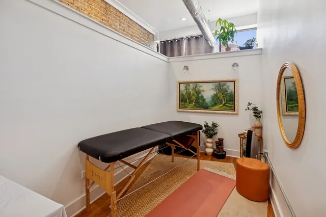a view of a bedroom with furniture and a mirror