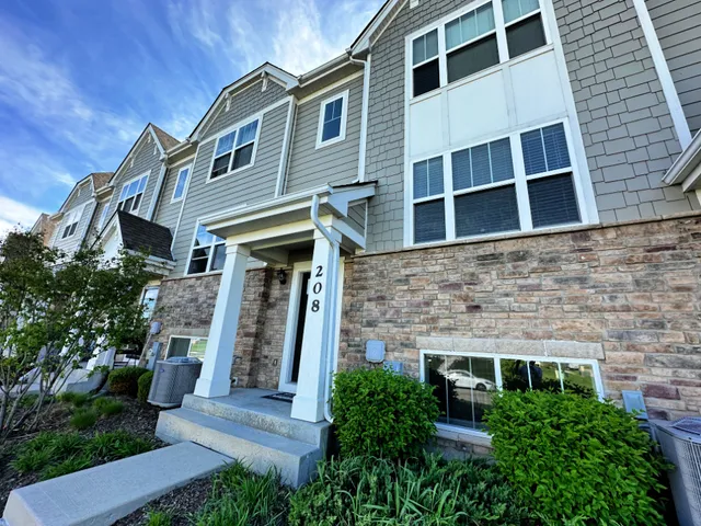 a front view of a house with plants
