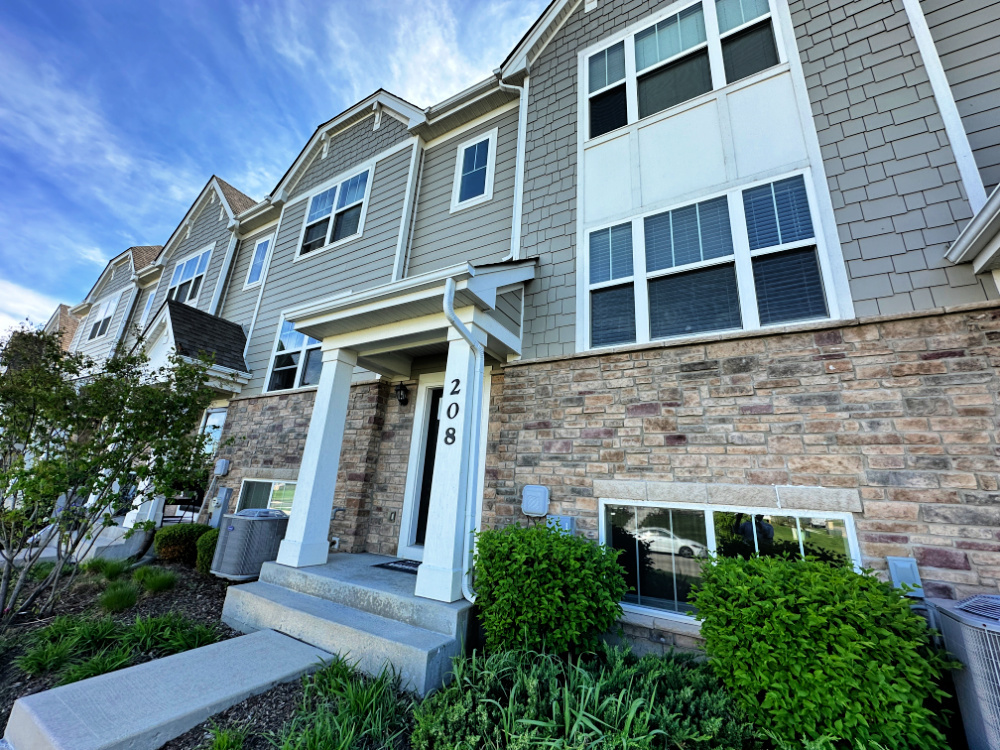 a front view of a house with plants