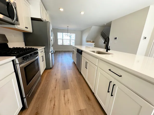 a kitchen with granite countertop white cabinets and white appliances