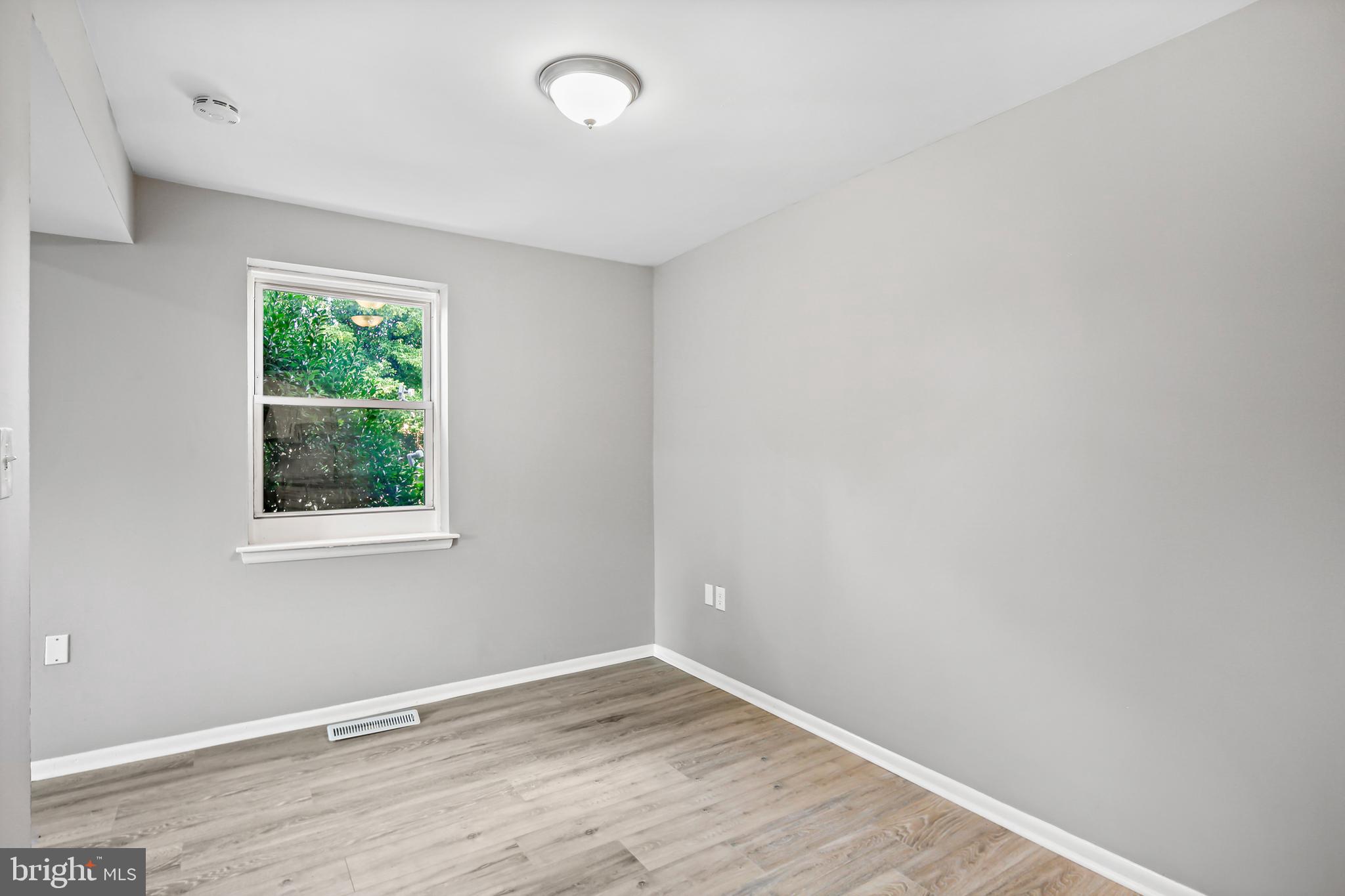 5636 Purdue Avenue Baltimore, MD 21239 - Photo 12 of 39 an empty room with wooden floor and windows