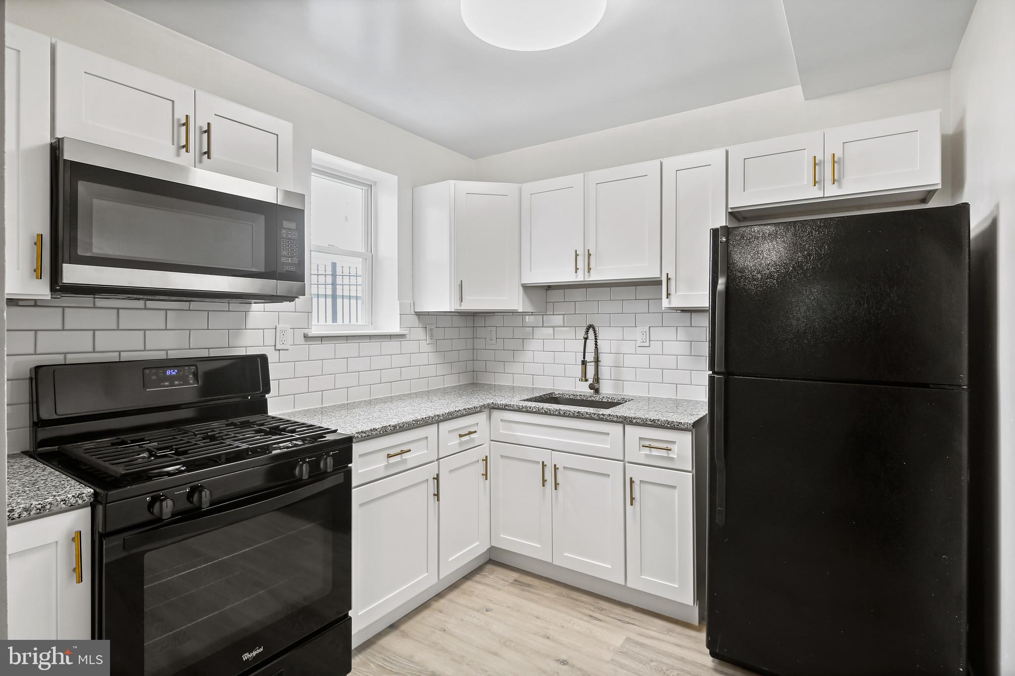 5636 Purdue Avenue Baltimore, MD 21239 - Photo 13 of 39 a kitchen with a refrigerator stove and microwave