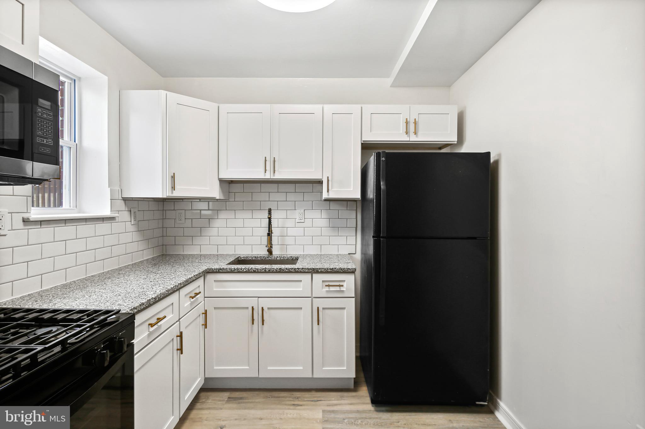 5636 Purdue Avenue Baltimore, MD 21239 - Photo 14 of 39 a kitchen with a sink a refrigerator and cabinets