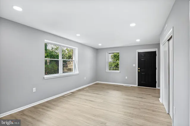 an empty room with windows and closet