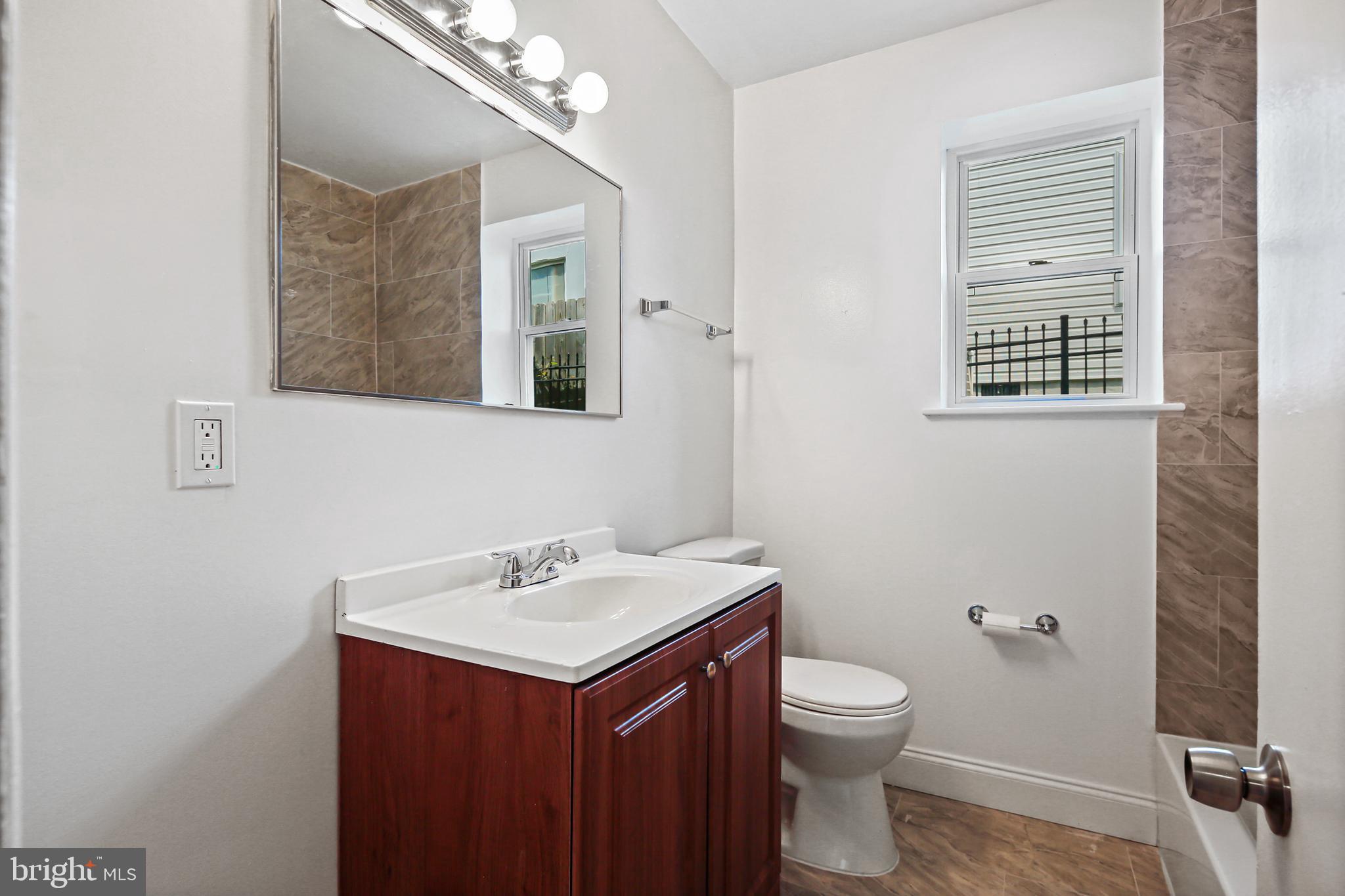 5636 Purdue Avenue Baltimore, MD 21239 - Photo 20 of 39 a bathroom with a sink a light fixture and a toilet