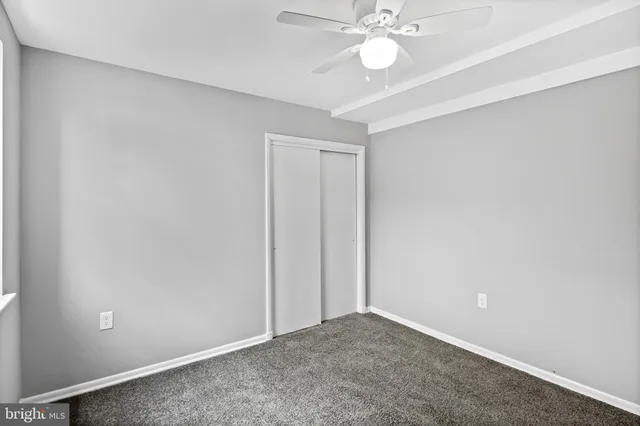 an empty room with a chandelier fan and a fan