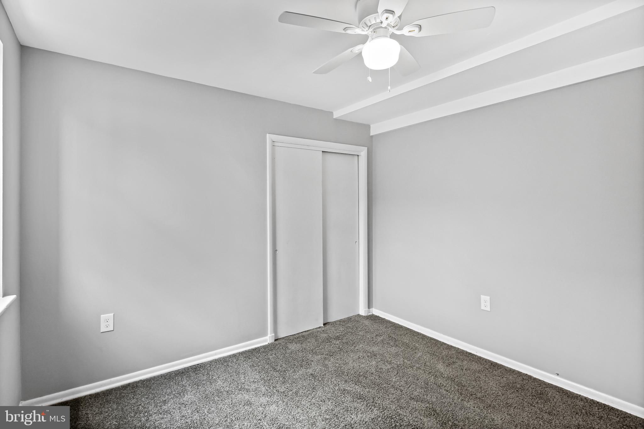 5636 Purdue Avenue Baltimore, MD 21239 - Photo 25 of 39 an empty room with a chandelier fan and a fan