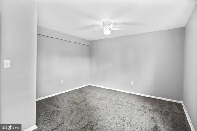 an empty room with a chandelier fan and closet