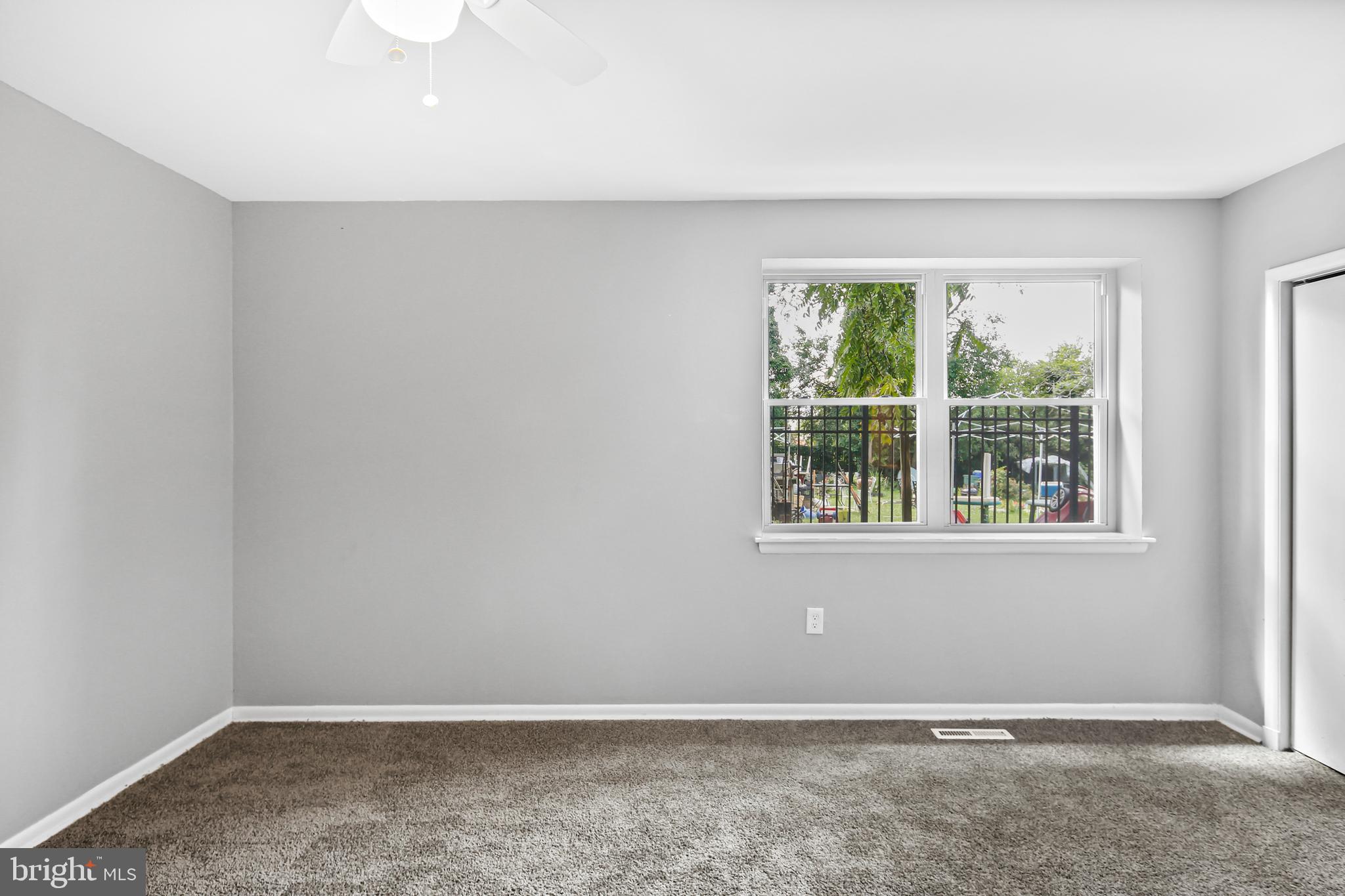 5636 Purdue Avenue Baltimore, MD 21239 - Photo 36 of 39 an empty room with wooden floor and windows