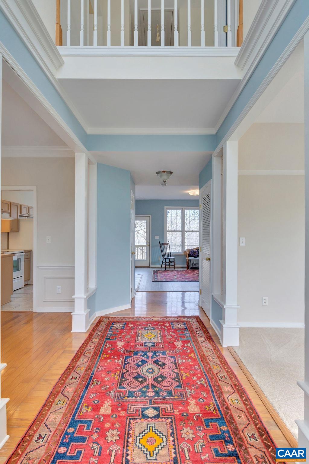 320 Starcrest Road Charlottesville, VA 22902 - Photo 4 of 38 a view of a hallway to a livingroom with wooden floor and a rug