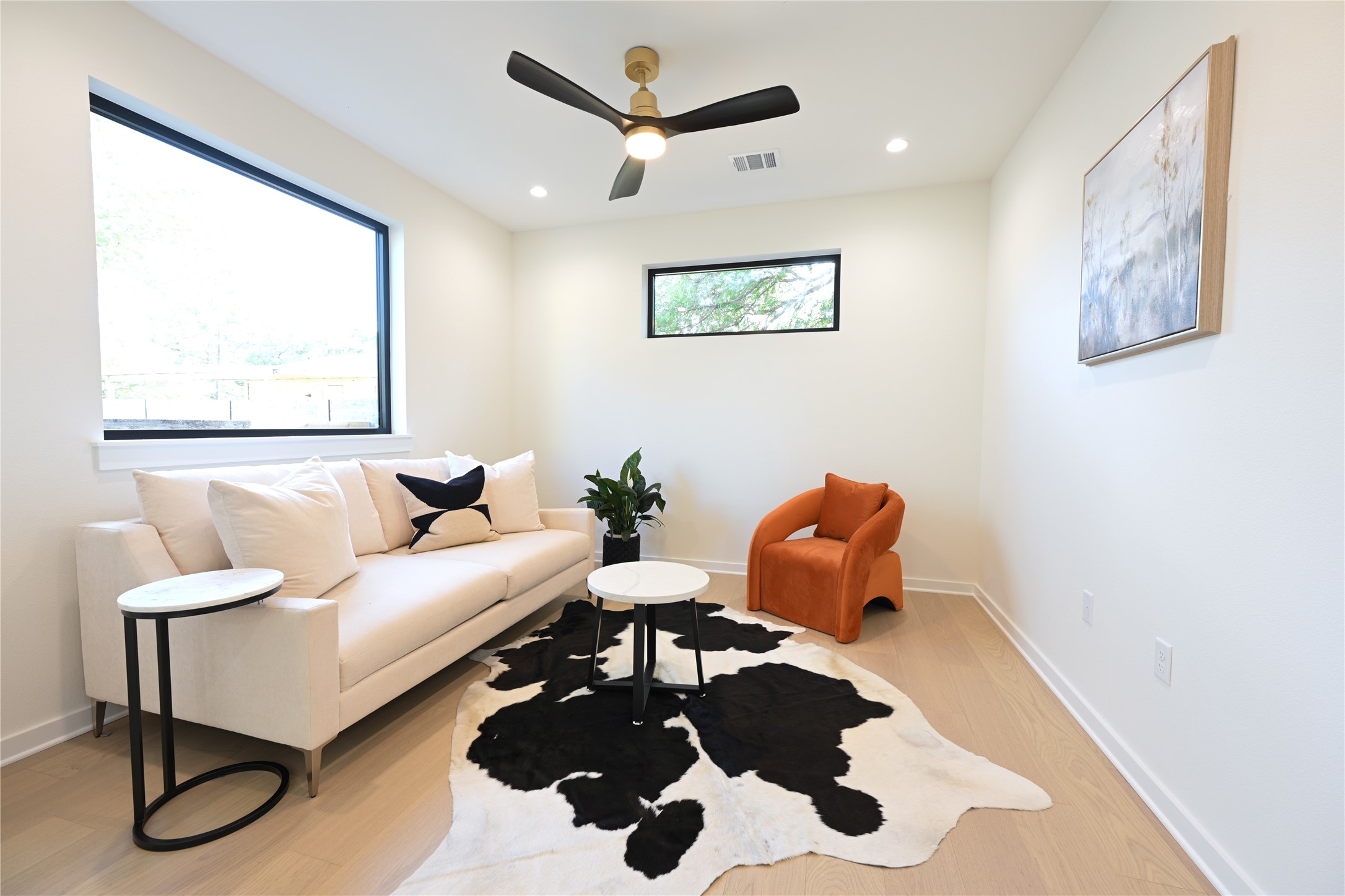 4410 Glomar Avenue, Unit 2 Austin, TX 78721 - Photo 4 of 24 Bright room featuring large windows, light-colored flooring, and a ceiling fan with integrated lighting