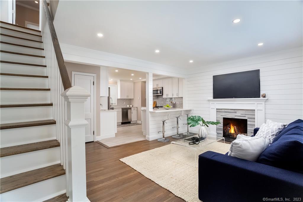 1748 Stratfield Road Fairfield, CT 06825 - Photo 15 of 30 a living room with furniture a fireplace and a flat screen tv
