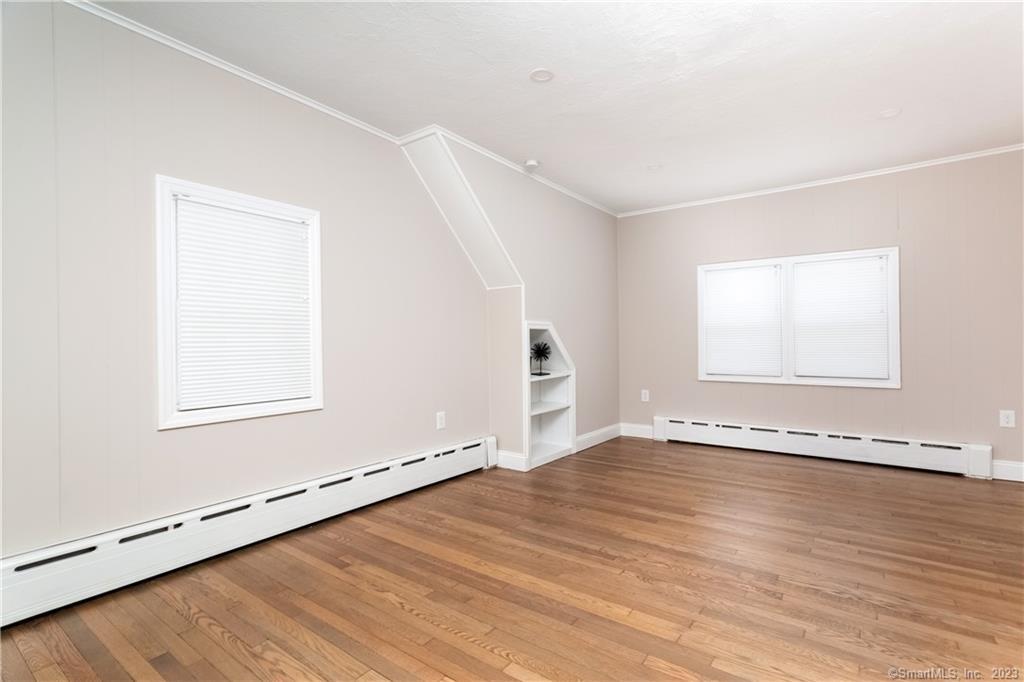 1748 Stratfield Road Fairfield, CT 06825 - Photo 23 of 30 an empty room with wooden floor and windows