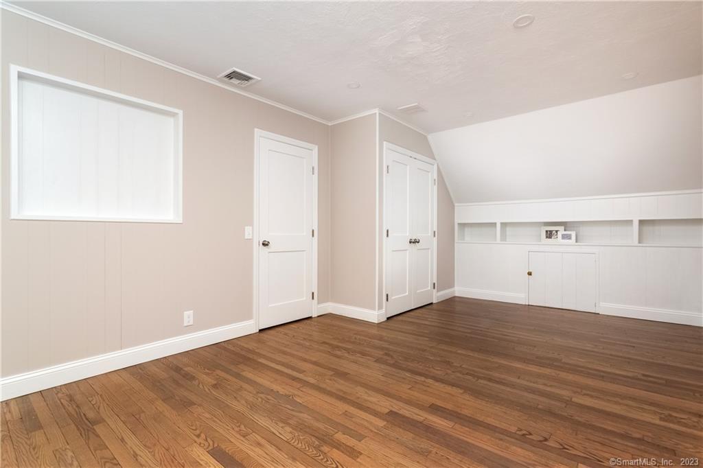 1748 Stratfield Road Fairfield, CT 06825 - Photo 24 of 30 a view of an empty room with wooden floor and a window