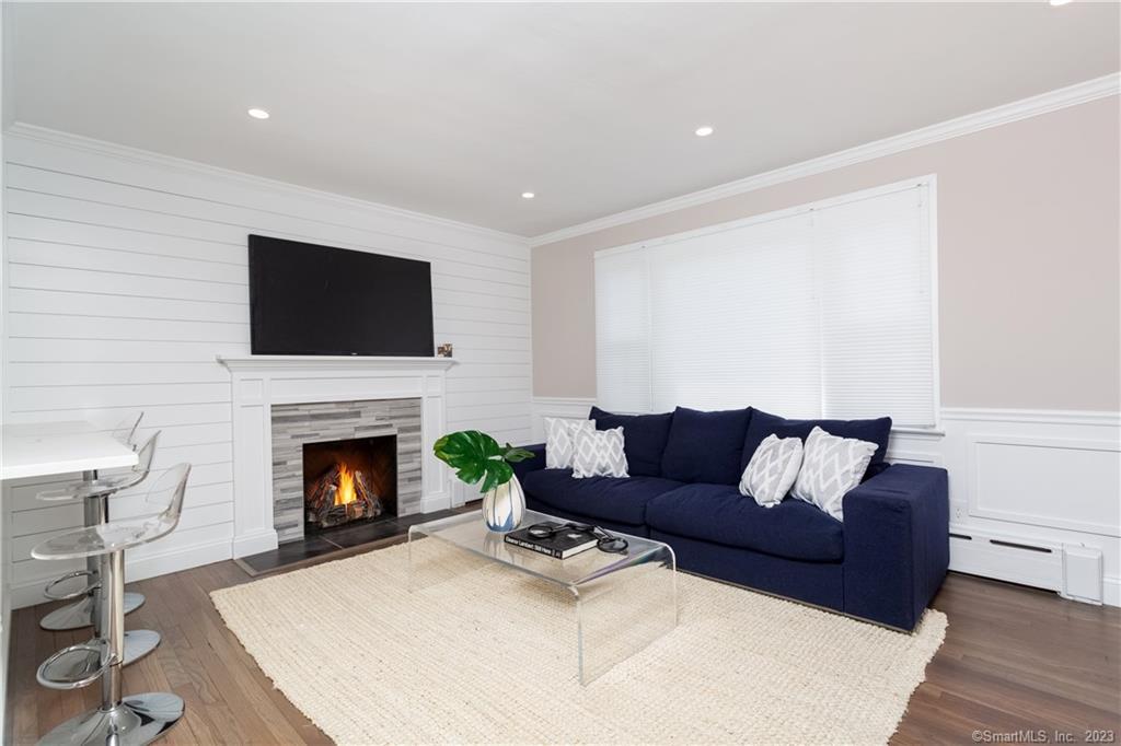 1748 Stratfield Road Fairfield, CT 06825 - Photo 6 of 30 a living room with furniture a flat screen tv and a fireplace