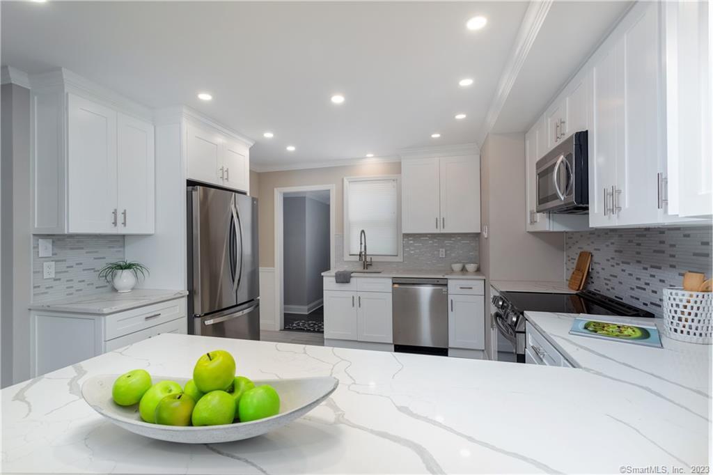 1748 Stratfield Road Fairfield, CT 06825 - Photo 8 of 30 a kitchen with stainless steel appliances kitchen island granite countertop a sink a refrigerator a stove a dining table and chairs