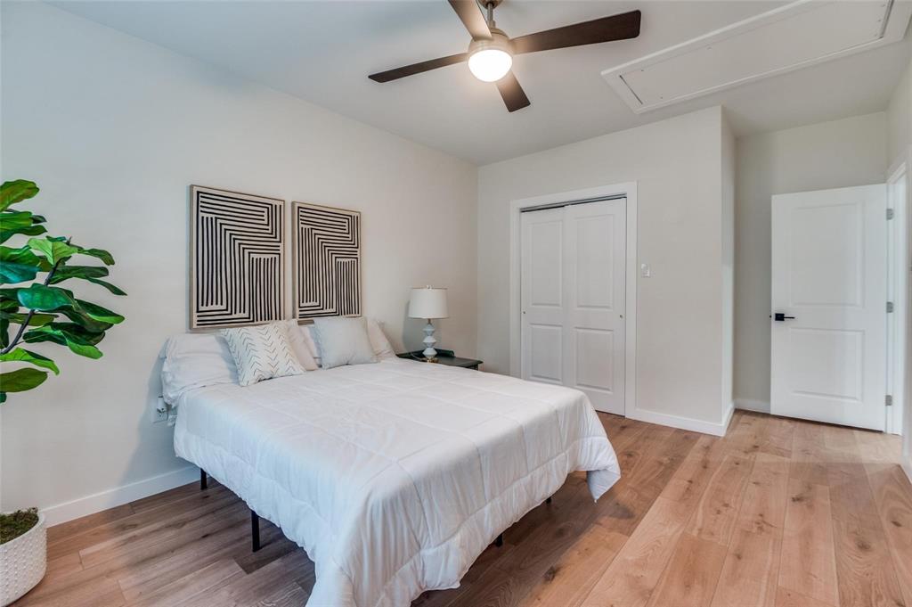 602 Brooks Avenue Dallas, TX 75208 - Photo 11 of 22 a bedroom with a large bed and a potted plant