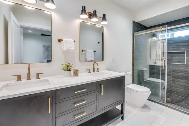 a bathroom with a double vanity sink mirror and toilet