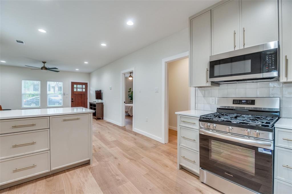 602 Brooks Avenue Dallas, TX 75208 - Photo 8 of 22 a kitchen with stainless steel appliances white cabinets and a stove top oven