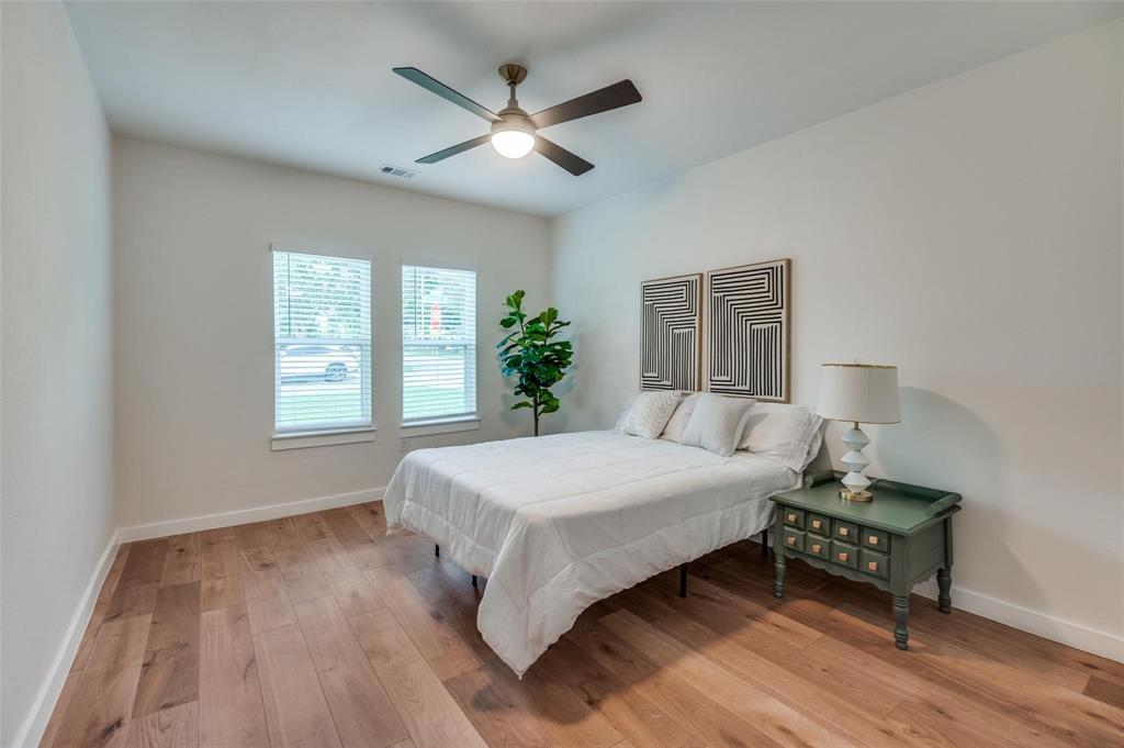 602 Brooks Avenue Dallas, TX 75208 - Photo 10 of 22 a bedroom with a bed chandelier and a window