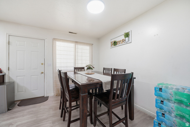 203 North Geneva Road, Unit 10 Provo, UT 84601 - Photo 5 of 30 Dining area featuring light-toned wood-finish flooring, a white paneled door, and a window with blinds
