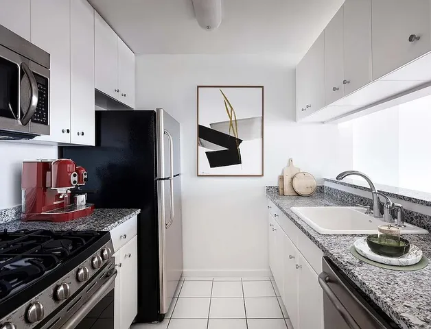 a kitchen with granite countertop stainless steel appliances and wooden cabinets
