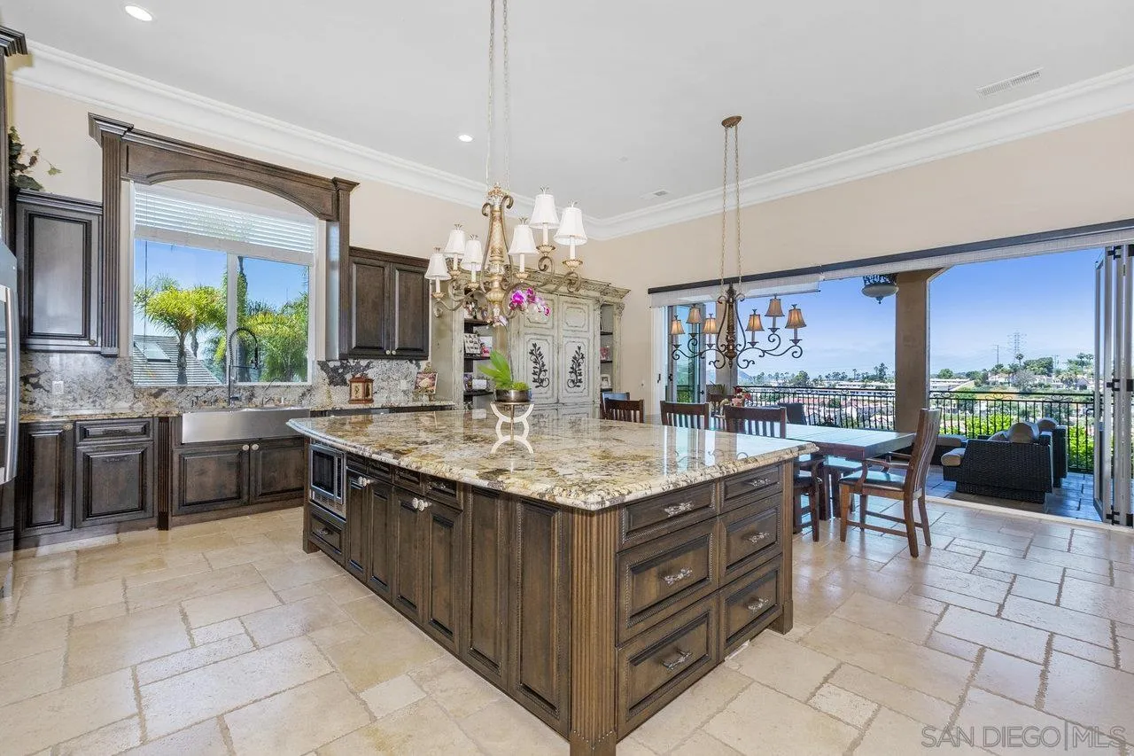 7342 Altiva Place Carlsbad, CA 92009 - Photo 12 of 56 a kitchen with kitchen island granite countertop a sink counter and chairs