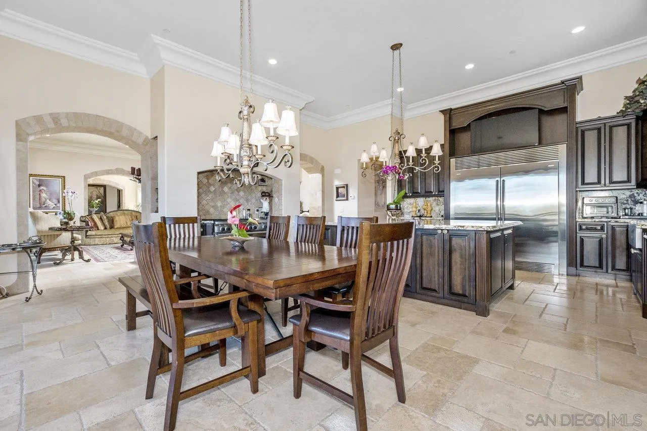 7342 Altiva Place Carlsbad, CA 92009 - Photo 14 of 56 a dining room with furniture a chandelier kitchen view and a chandelier
