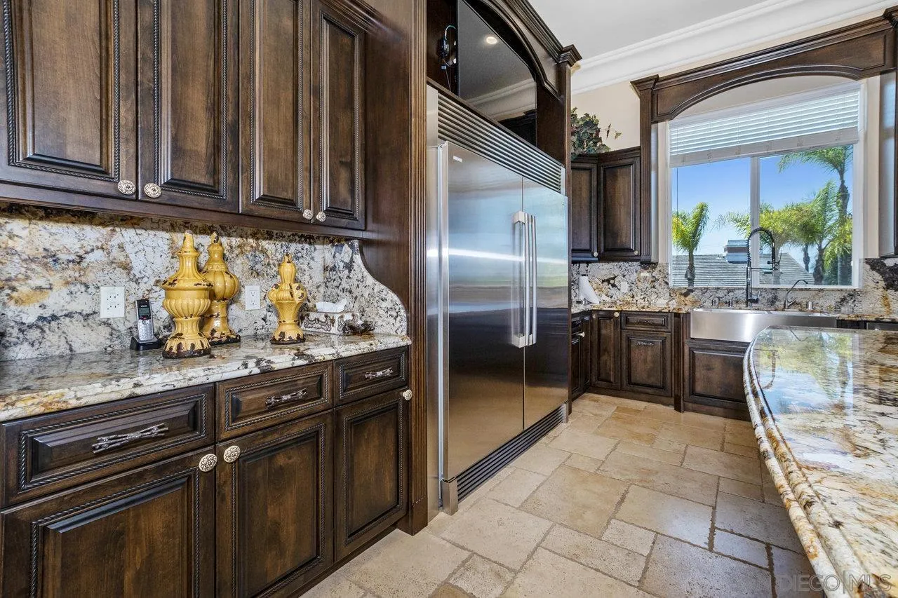 7342 Altiva Place Carlsbad, CA 92009 - Photo 17 of 56 a kitchen with stainless steel appliances granite countertop a stove a sink and a microwave