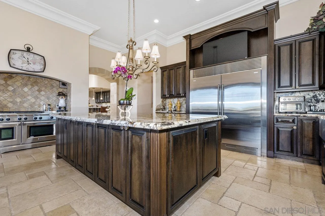 7342 Altiva Place Carlsbad, CA 92009 - Photo 18 of 56 a kitchen with stainless steel appliances kitchen island granite countertop a refrigerator and a stove