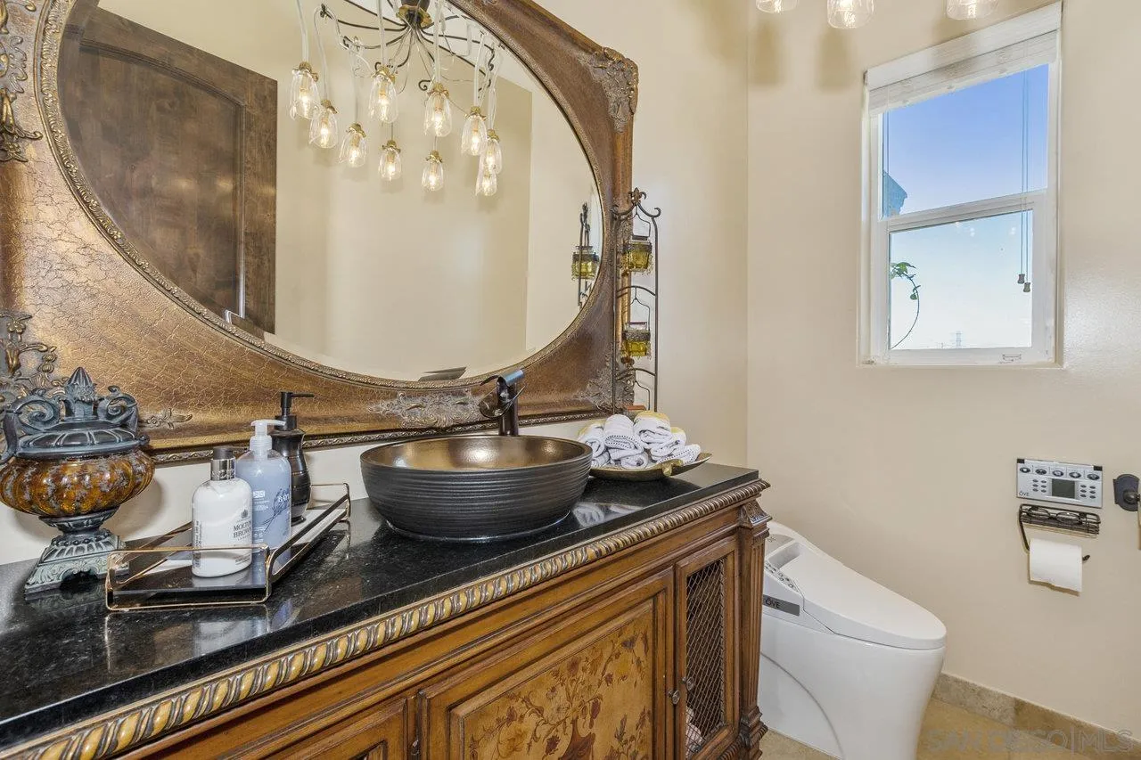 7342 Altiva Place Carlsbad, CA 92009 - Photo 31 of 56 a bathroom with a granite countertop toilet a sink and mirror
