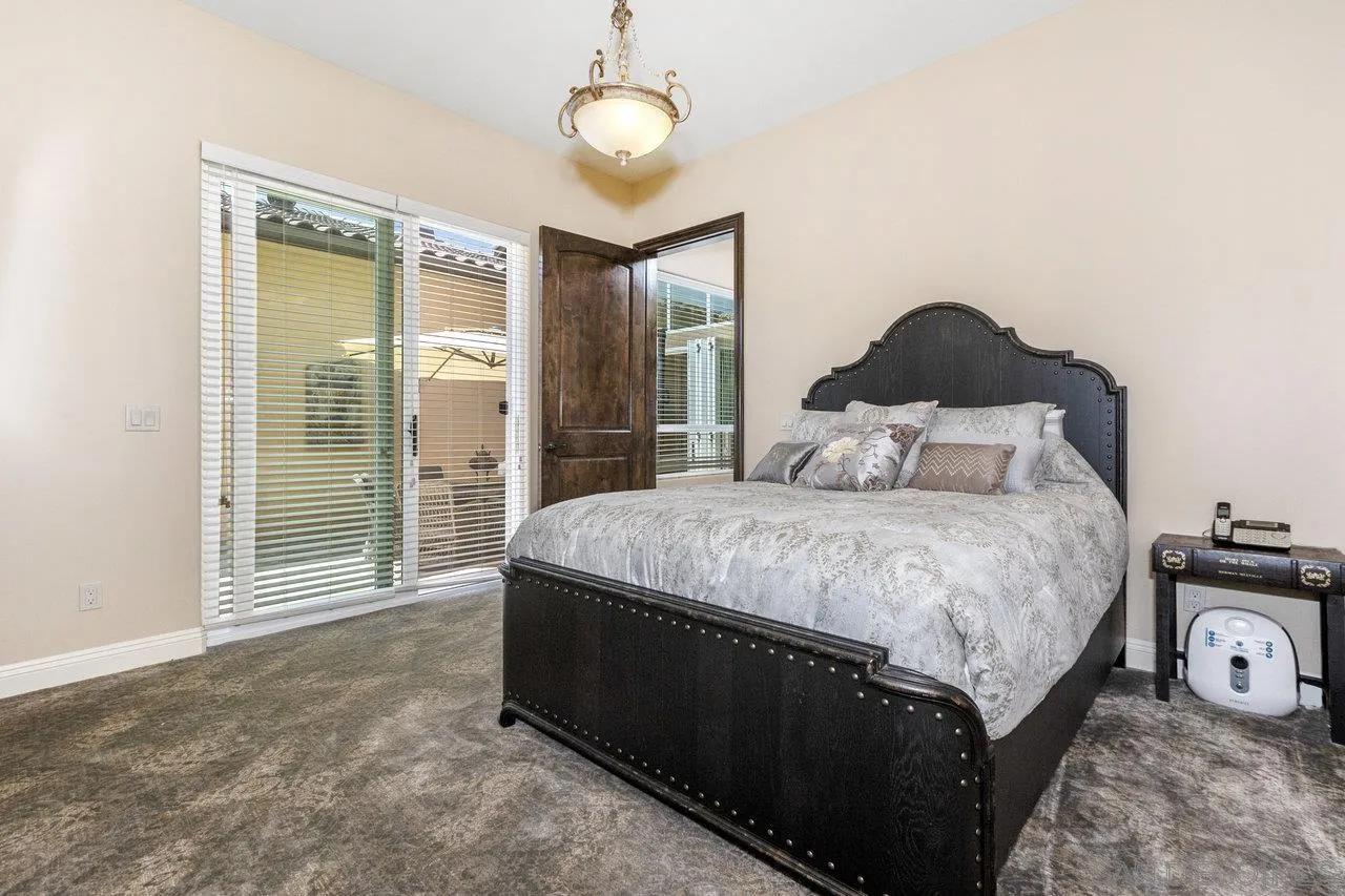7342 Altiva Place Carlsbad, CA 92009 - Photo 33 of 56 a spacious bedroom with a bed and a lamp next to a window
