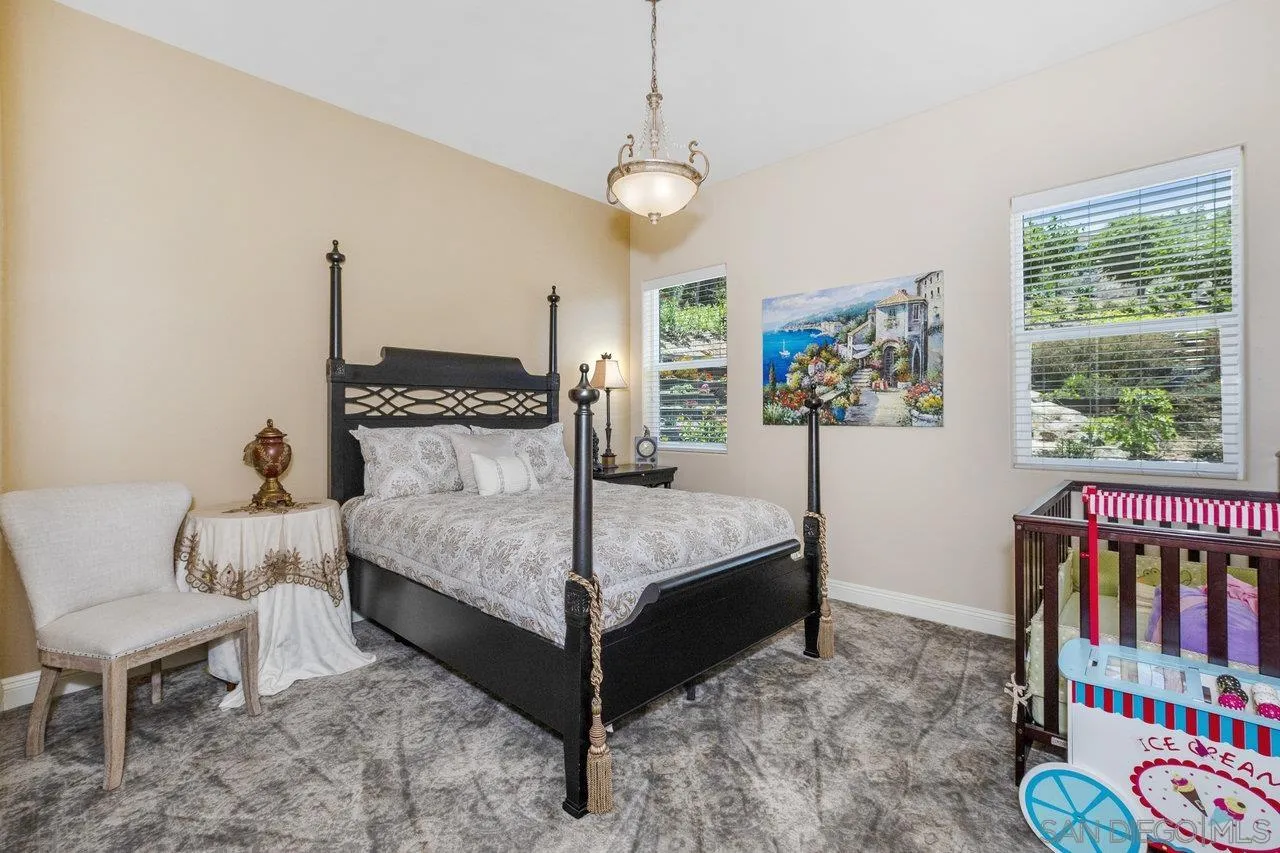 7342 Altiva Place Carlsbad, CA 92009 - Photo 34 of 56 a bedroom with a bed a couch and a window
