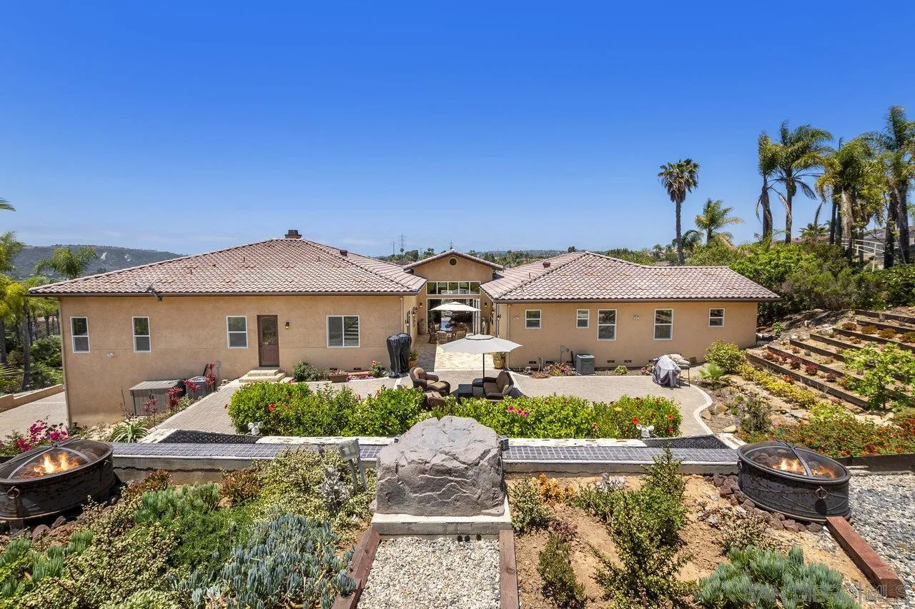 7342 Altiva Place Carlsbad, CA 92009 - Photo 49 of 56 a front view of a house with a yard and potted plants