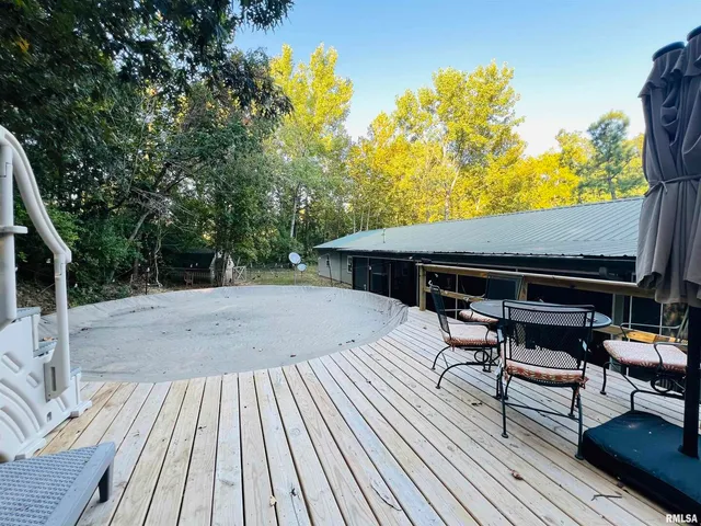a view of house with deck outdoor seating and trees