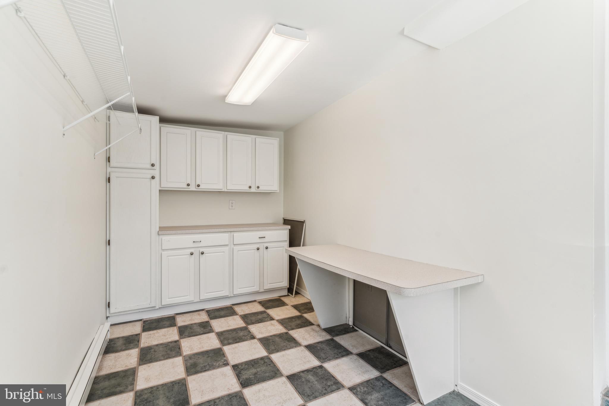 436 Penn Valley Road Penn Valley, PA 19072 - Photo 30 of 64 a kitchen with a checkered floor and white cabinets