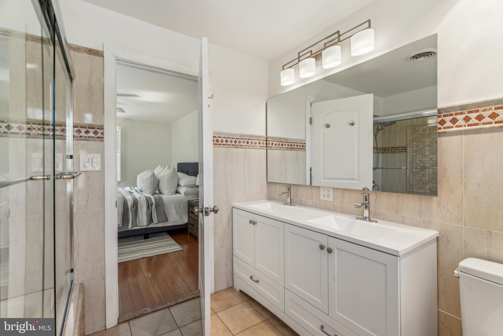 436 Penn Valley Road Penn Valley, PA 19072 - Photo 35 of 64 a en suite bathroom with a sink a mirror and a shower